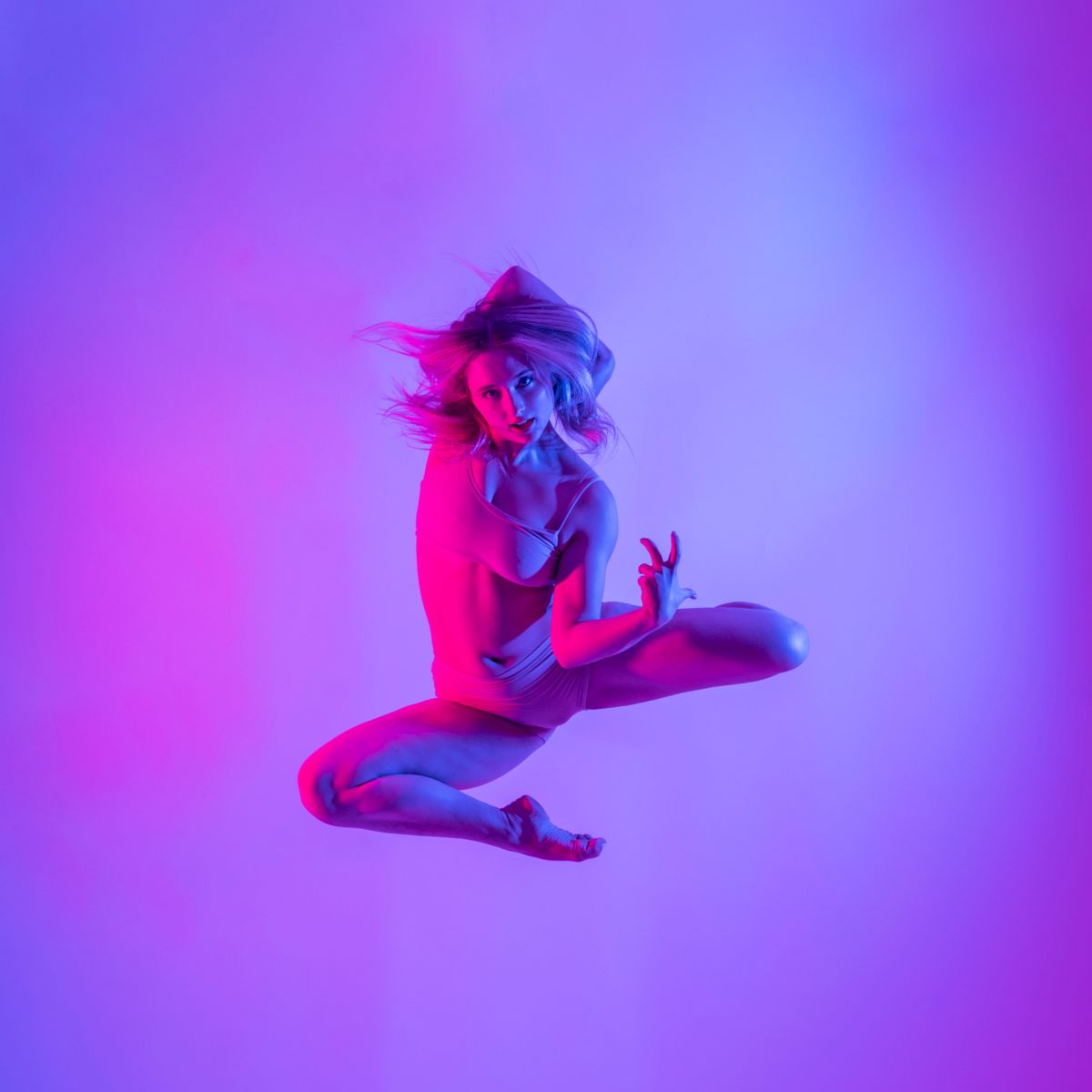 A light-skinned dancer is suspended in a jump