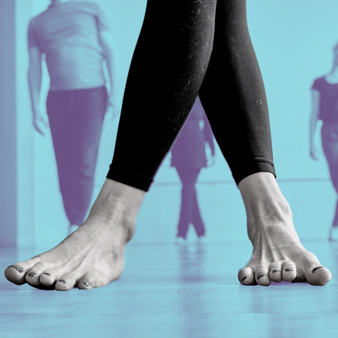 An image of two feet, one leg crossed in front of the other. Both feet try to press flat to the floor