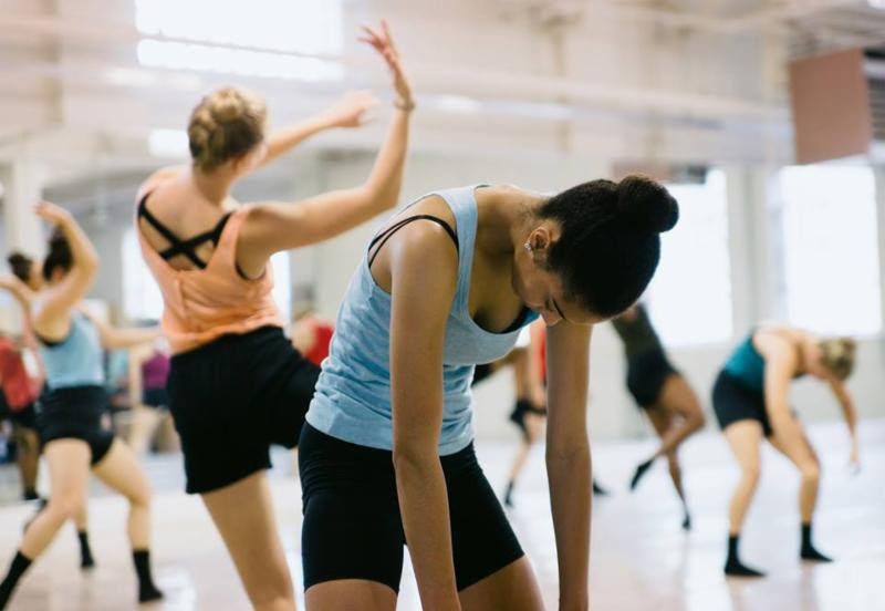 A group of young dancers of different skin tones dance in the TU Dance Center Studio